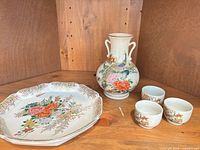 Group shot of vase, platter and three cups on shelf