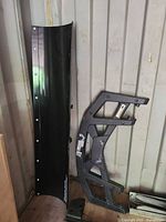 Polaris Glacier plow blade upright beside Arctic Cat rack and hitch piece