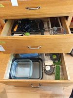 Drawer showing glass baking dishes, metal pans, food chopper and accessories