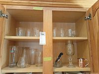 Cabinet view showing assortment of glasses across two shelves