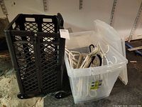 rolling cart beside open clear tote filled with hangers, second tote lid shown