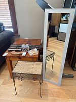 Mirror, wicker table, and assorted decor on table