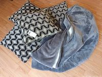 Group view of four pillows and grey sherpa blanket