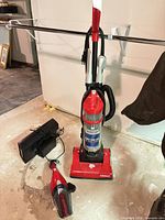 Upright vacuum, handheld vacuum and charging base on floor