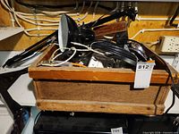Overview of wooden crate containing cords, power strips and lamp
