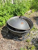 Overall view of fire pit with lid on showing perforated sidewall