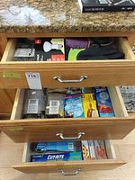 Three open drawers showing variety of household and pantry items