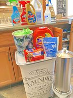 Full lot showing hamper, toilet paper holder, wastebasket, cleaning products