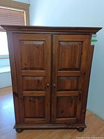 Front view showing paneled double doors and overall cabinet design