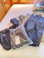 Assorted shorts on bed including bagged pair