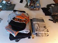 Overall lot showing folded apparel stacks, Holland toque, packaged thermal underwear