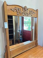 Front view of carved wood dresser mirror showing entire frame and mirror surface