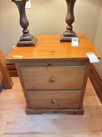 Front view of knotty pine night table showing two drawers and round knobs
