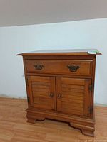Front view showing drawer, cabinet doors, hardware and feet