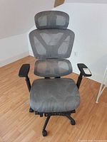 Front view of grey mesh ergonomic office chair showing overall design, arms and base