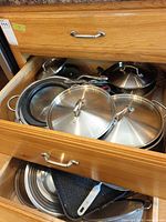 Drawer with multiple stainless lids, splatter guard, colander and grill pan