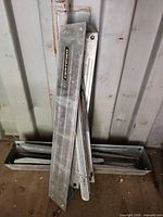 Both folded sawhorses leaning against wall showing Certified branding