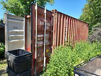Full side and partially open end of 20 ft brown steel sea container in outdoor setting