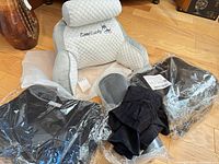 All items together: Good Lucky back-rest cushion with neck roll, Nira cushions in plastic, compression shirt package