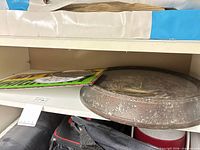 Clock, sign and surrounding context on shelf
