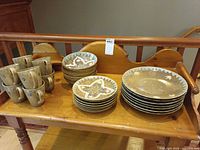 Full set on wooden bench showing mugs and plate stacks