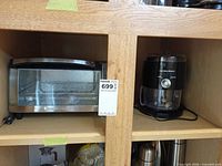 Black & Decker toaster oven next to Hamilton Beach slushie maker on shelf