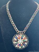 Full view of necklace on display bust showing chain and pendant