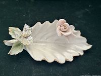 Top view of porcelain leaf dish with crystal accent and pink rose