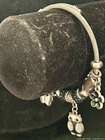 Bracelet on display bar showing cable construction and hanging charms