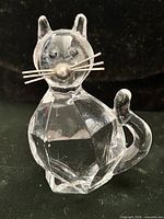 Front view of faceted glass cat figurine with metal whiskers