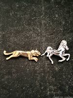 Both brooches side by side showcasing size and color contrast
