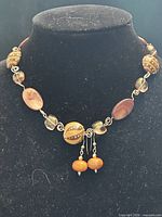 Full view of necklace with earrings hanging from center