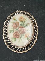 Front view showing porcelain floral insert and gold-tone frame