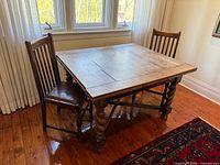 Closed view of oak draw-leaf table with two chairs