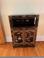 full front view of cabinet showing display niche and decorated doors