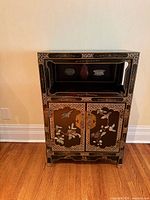 Front view showing entire cabinet, upper shelf, hardstone inlay on doors