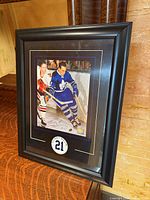 Frontal view of framed Bobby Baun signed photo on shelf