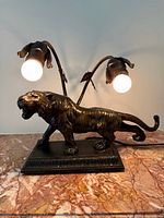 Front view of bronze-tone tiger lamp with bulbs lit