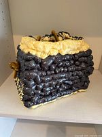 Front view of black and cream foam bag with cord handles