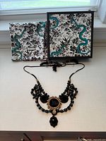 Full view of necklace with Gucci pouch and box
