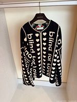 Front view of Gucci wool coat displaying overall design and text motif