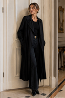 Model wearing full-length black pleated silk Gucci trench coat