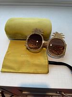 Front view of Gucci pineapple sunglasses with case and pouch
