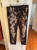 Front view of Gucci bleached jeans hanging