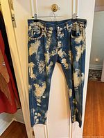 Front view of bleached Gucci jeans hanging