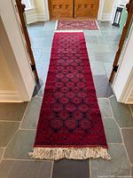 Full length view of red Bokhara runner with fringe
