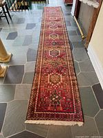 Full length view of runner on stone floor, showing pattern and fringe