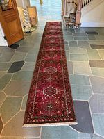 Full length view of red Persian runner on slate tiles