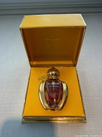 Bottle of Sublime parfum seated in yellow Jean Patou box