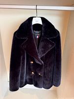 Front view of blue faux fur coat on hanger